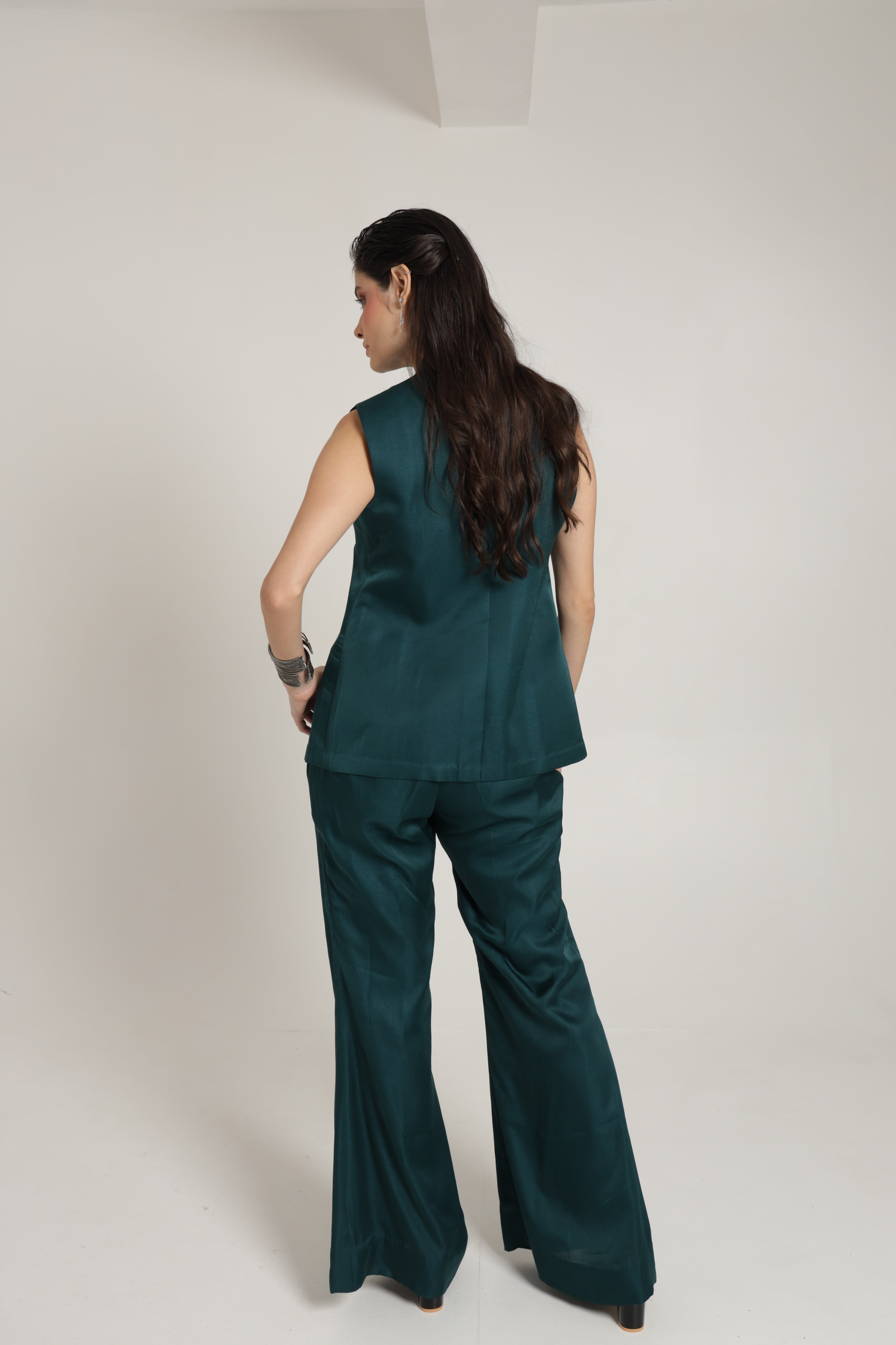 Teal green sleeveless jacket with bell bottom pants and bustier