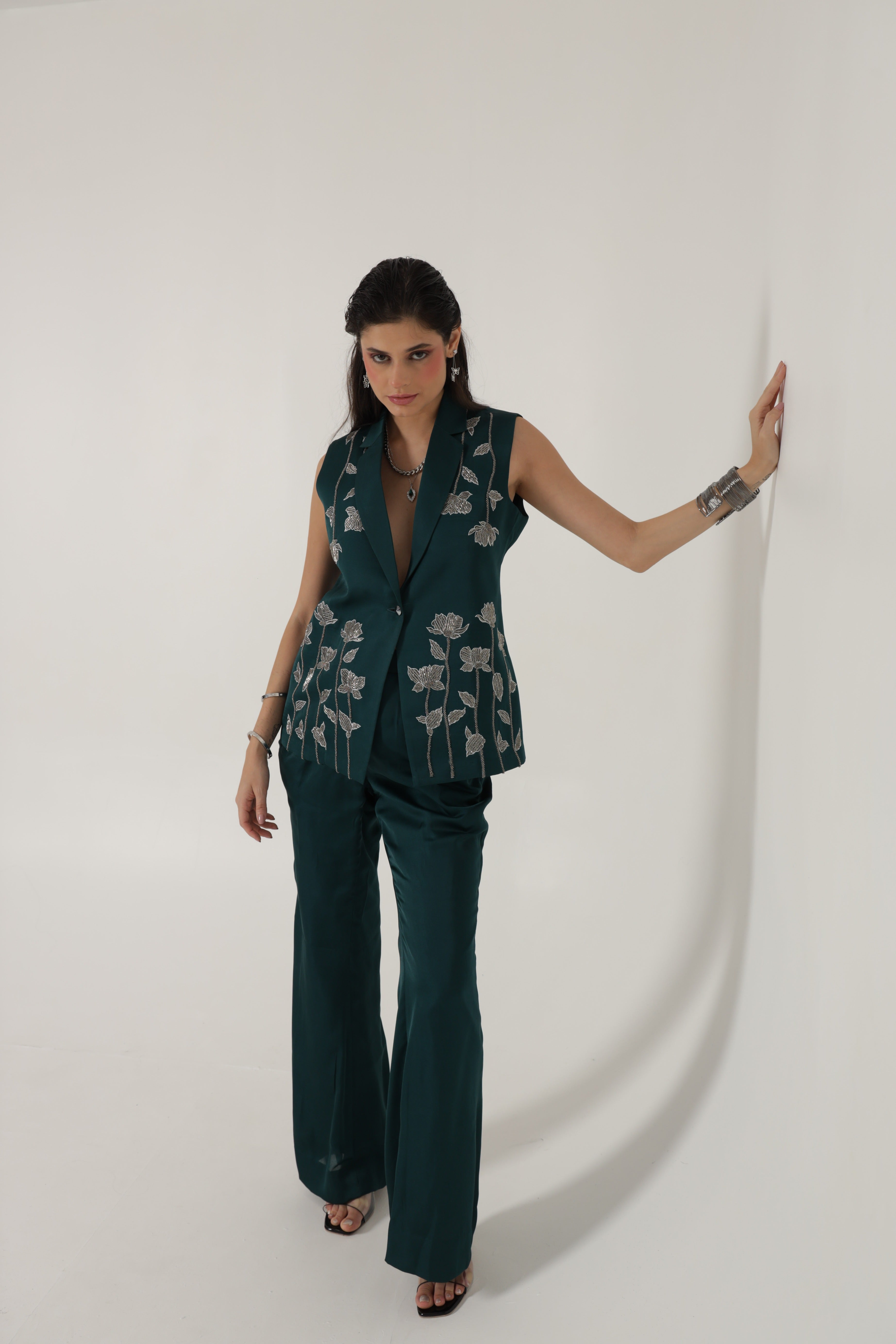 Teal green sleeveless jacket with bell bottom pants and bustier