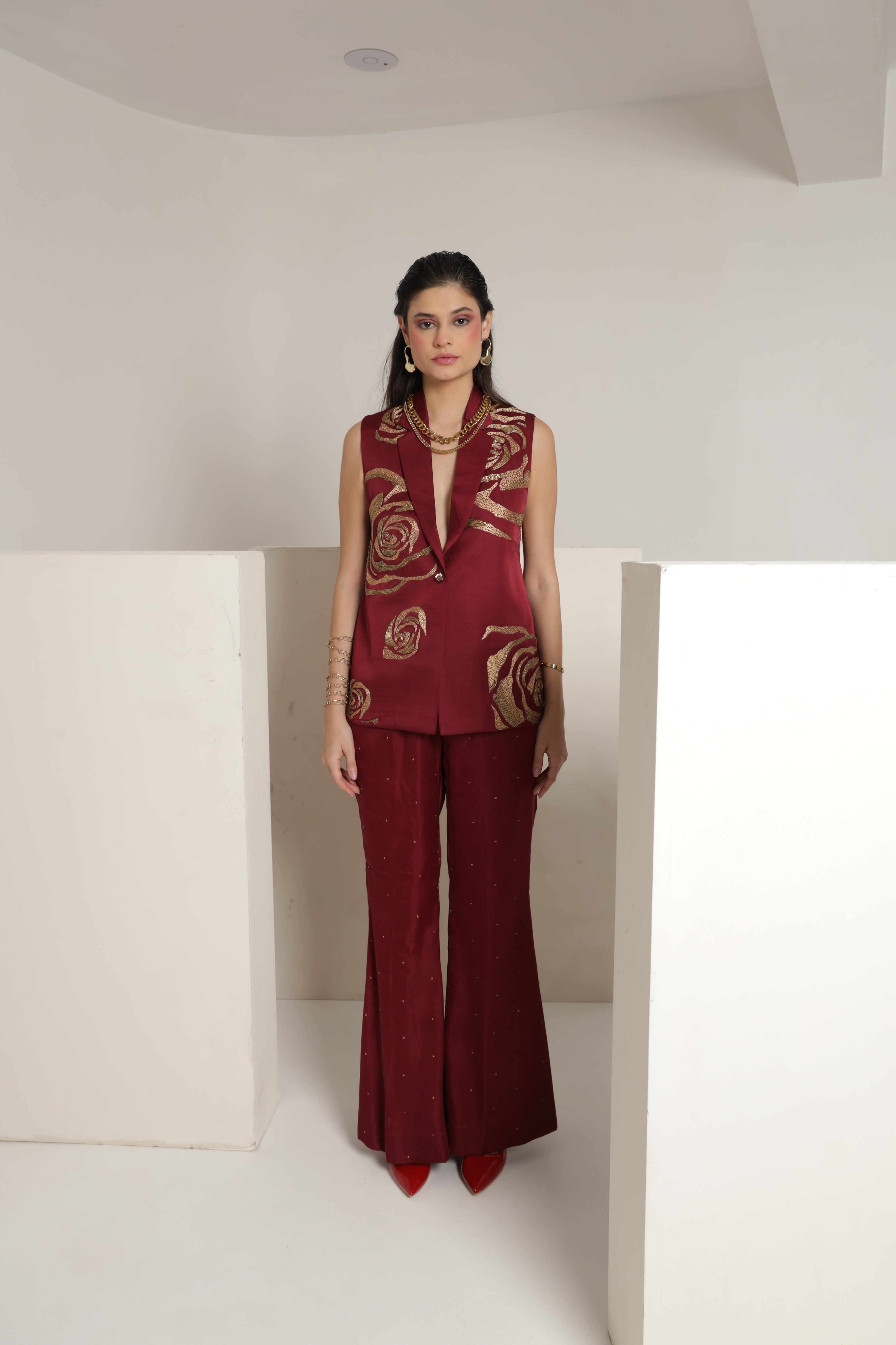 Maroon sleeveless jacket with bell bottom pants and a bustier