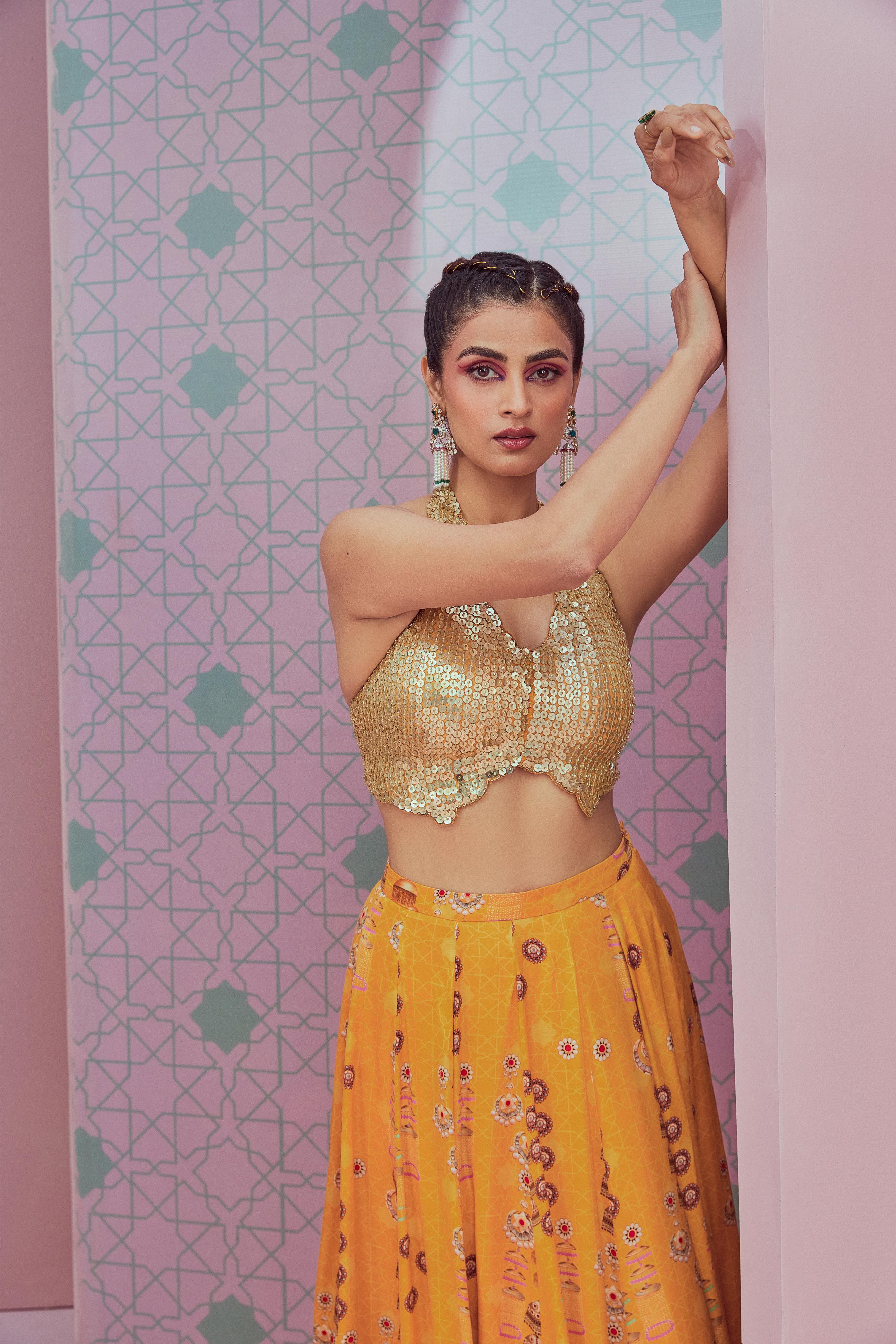 Sequence blouse paired with yellow flared lehenga