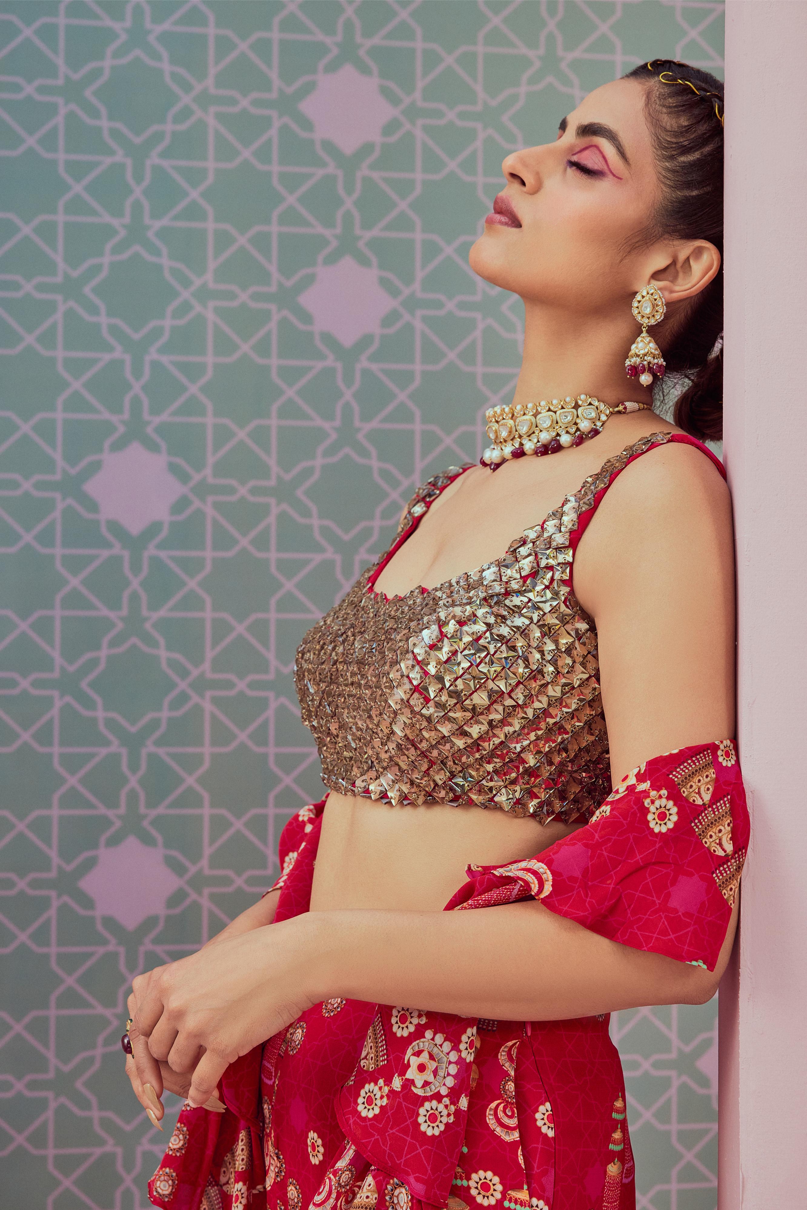 Crystal blouse paired with red ruffle saree drape