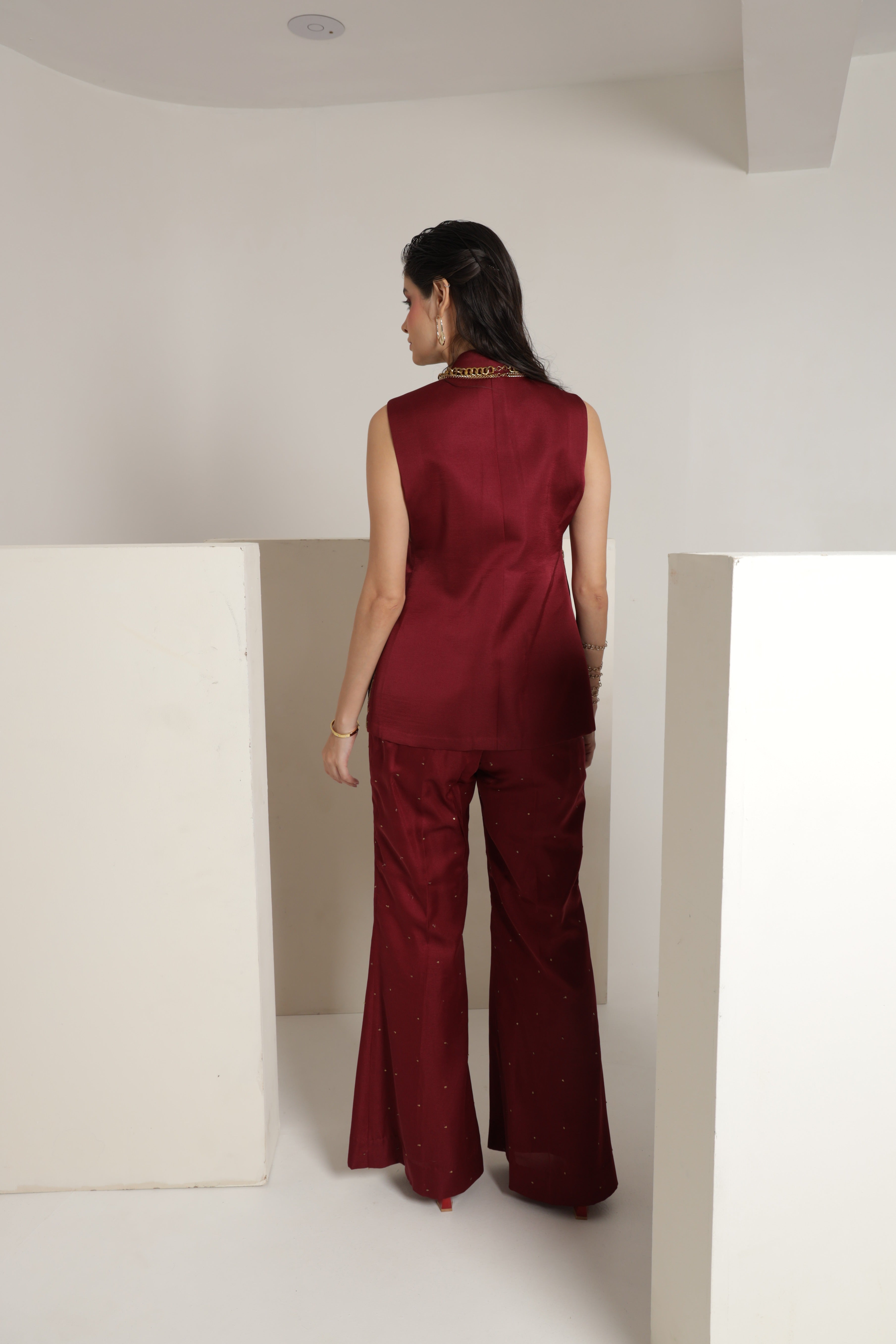 Maroon sleeveless jacket with bell bottom pants and a bustier
